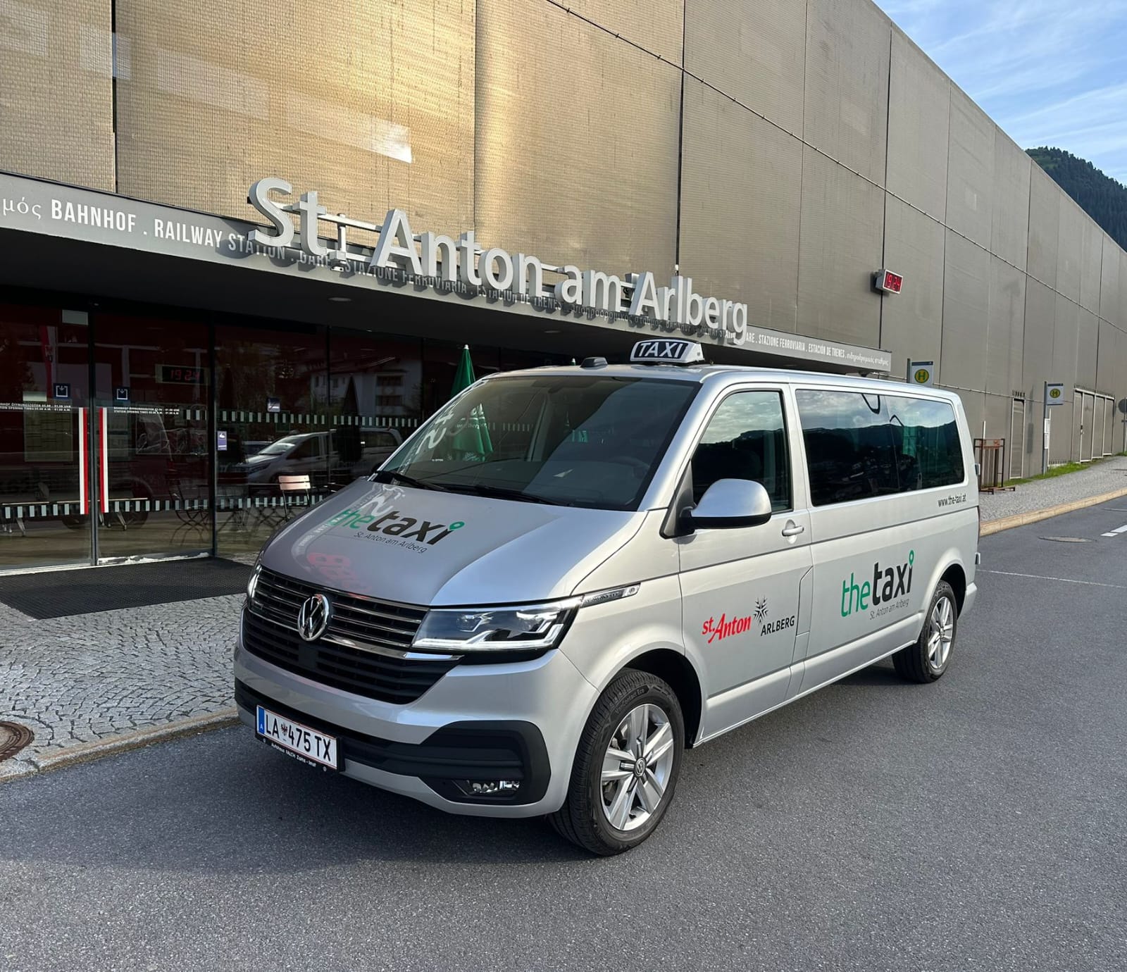 Mercedes V-Class taxi parked in front of a modern building with "St. Anton Am Arlberg" visible on the wall.